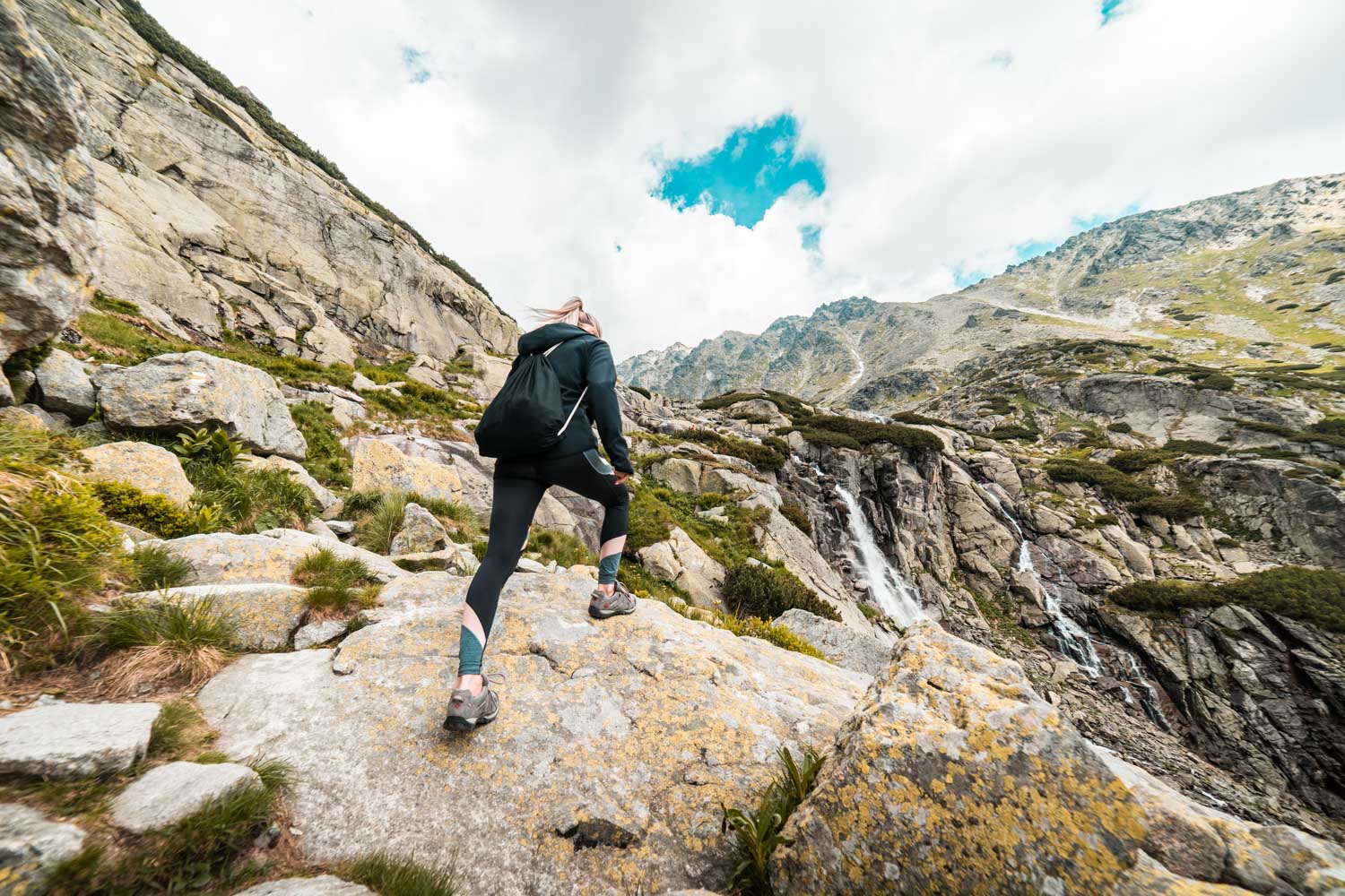 young fit woman hiking to the waterfall mountain free photo