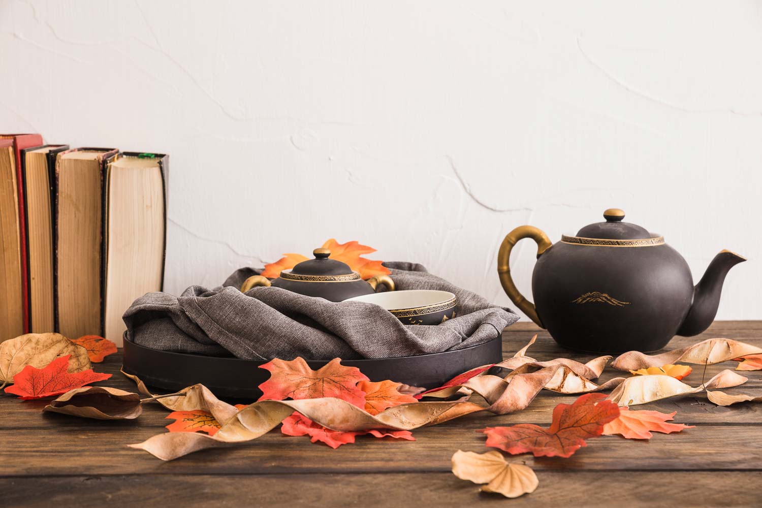 books leaves near tea set